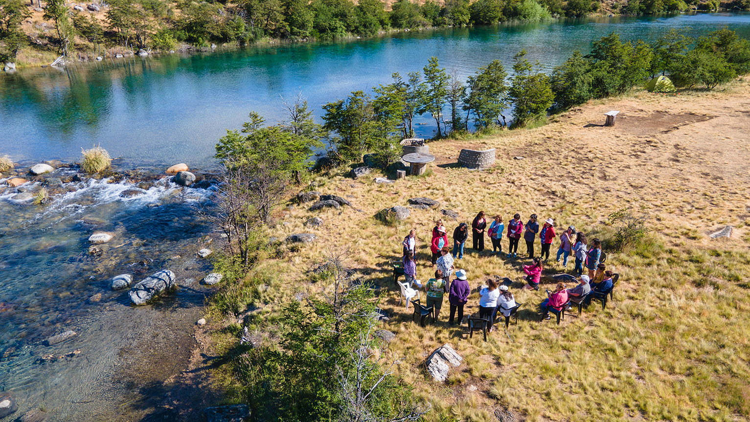 Grupo de artesanas de Aysén reunidas junto al río Cochrane